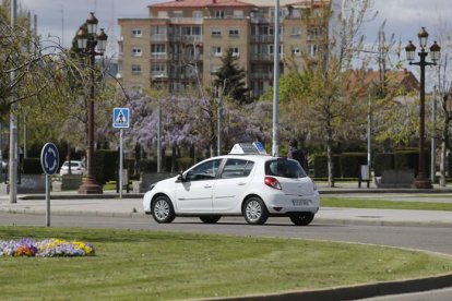 Un coche de autoescuela por las calles de León.