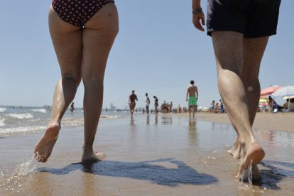 Una pareja pasea este sábado en la orilla de la playa de La Patacona de Alboraya, localidad junto a la ciudad de Valencia, MANUEL BRUQUE