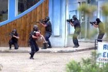 Un policía evacúa a una rehén durante el asalto a una entidad bancaria en Monteverde, Costa Rica