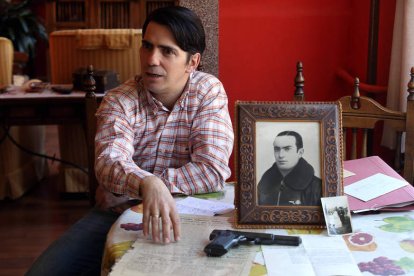 Javier Alonso de Quintanilla Peña, con el retrato de su abuelo, la pistola que empleó en vida y diversos documentos.