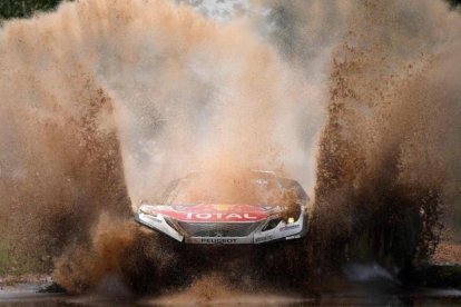 Sebastien Loeb (Peugeot) atraviesa un charco en la etapa de hoy del Dakar.
