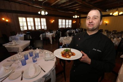 Arriba, Jorge Balboa con una de sus creaciones (alcachofas con langostinos, foie y molleja de pato). Abajo, el cocinero con su equipo de cocina, Vicky y Tere, en el restaurante.