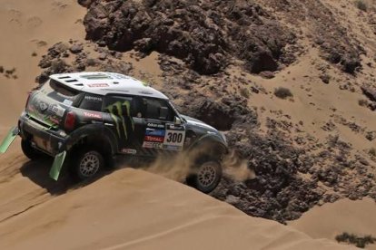 Stéphane Peterhansel supera con su mini un tramo complicado de arena en el rali Dakar.