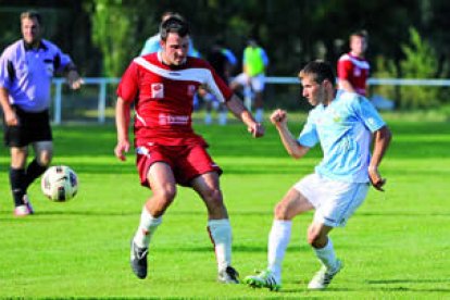 Ivi intenta controlar el balón ante la oposición de un jugador asturiano.