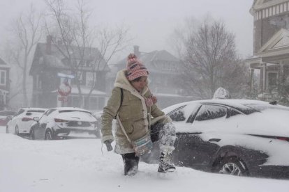 Una mujer camina semienterrada en Buffalo, ayer. JALEN WRIGHT