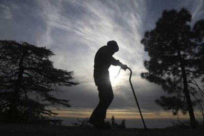 Un anciano contempla el atardecer paseando por el monte. SANJAY BAID