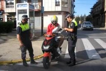 Dos agentes de la policía realizan un control a un motorista, en una imagen de archivo