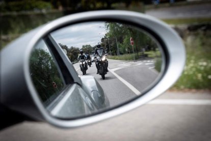 Un grupo de motoristas se reflejan en el retrovisor de un coche. FERNANDO VILLAR