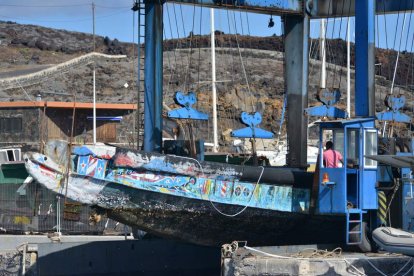 Varios operarios sacan del muelle de la Restinga los cayucos acumulados. GELMERT FINOL