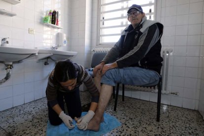 Sefi Herrero, gerente de Calor y Café, corta las uñas a Mario González Pérez. MARCIANO PÉREZ