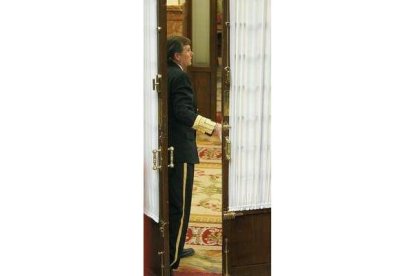 Un ujier cierra una puerta del Congreso.