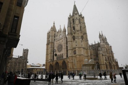 Gente junto a la Catedral de León este sábado, durante la nevada. FERNANDO OTERO