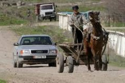 Un campesino circula delante de un automóvil en una carretera a 50 kilómetros de la capital, Bishkek