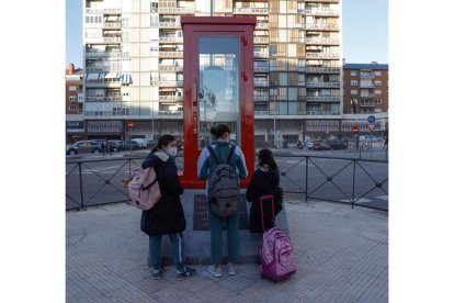 Tres niñas miran la cabina instalada ayer en el barrio de Chamberí. EFE