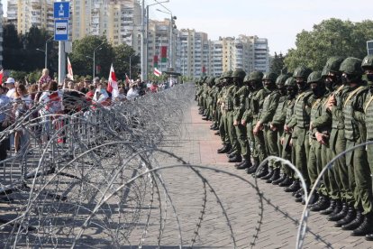 Los manifestantes se encaran a la policía tras la alambrada. STRINGER