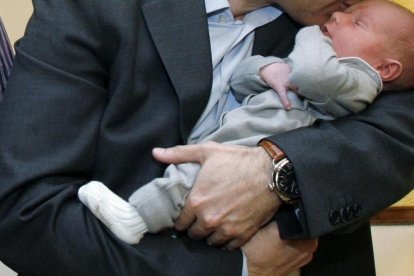 Un hombre con su hijo, disfrutando de un permiso de paternidad.