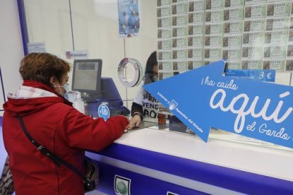 Una mujer sella un boleto de lotería. RAMIRO