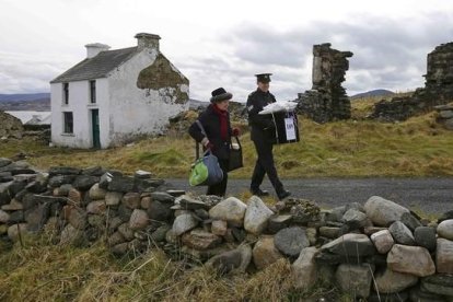 Dos oficiales se llevan la urna de la isla irlandesa de Inishbofin.