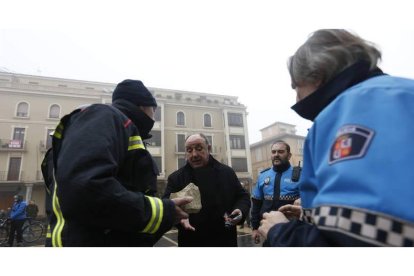 Un bombero entrega al administrador de la Catedral, Mario González, un fragmento del vierteaguas que se precipitó contra la plaza de Regla.