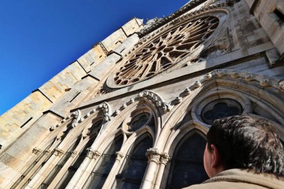 Un hombre contempla el rosetón de la fachada principal de la Catedral de León, cuya restauración financiará la Fundación Cepa. RAMIRO
