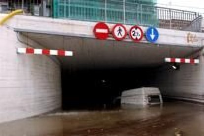 Un coche atrapado en el interior de un paso subterráneo de la estación de Renfe en El Masnou