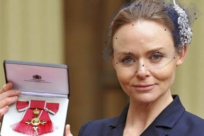 La diseñadora Stella McCartney muestra la medalla tras recibir el título oficial de la Orden del Imperio Británico.