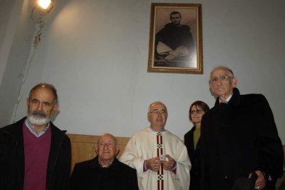 El párroco muestra la reliquia bajo una fotografía del beato.