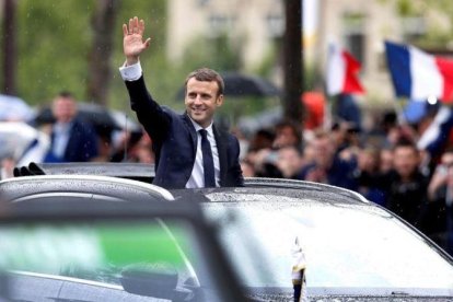 Macron saluda a la multitud desde su coche presidencial en París.