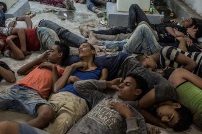 Supervivientes del naufragio duermen en una comisaría tras ser rescatados.