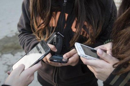 Unas adolescentes usan sus teléfonos móviles en Barcelona, en enero pasado.