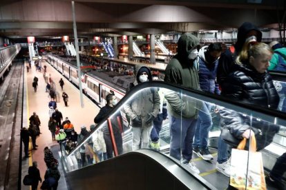 Varios usuarios protegidos con mascarillas transitan a primera hora de este martes la estación de Cercanías de Madrid-Atocha. MARISCAL