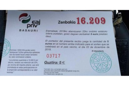 Participación de un cuarto de décimo de la lotería de Navidad emitida para el sorteo de este año por la sede del PNV en Basauri (Vizcaya). En el aviso central, la indicación de que se trata de lotería del país vecino.