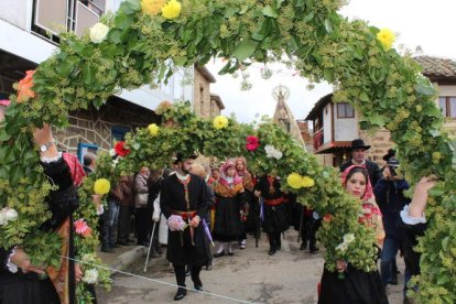 Las maragatas portan los coloridos arcos florales que preceden a la Virgen de los Remedios en la procesión