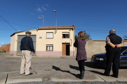 Varios vecinos contemplan la vivienda incendiada el lunes.