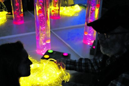 Haces de luz de colores y tubos de burbujas para estimular los sentidos en una sala Snoexelen en el Centro Alhéimer de León. J. NOTARIO