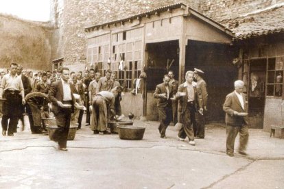 Imagen de la prisión provincial de León con los reclusos recogiendo el rancho en el patio, el mismo lugar donde comían por falta de comedor. MANUEL MARTÍN DE LAMADRID