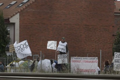 Vecinos y miembros de la plataforma por el soterramiento de Trobajo, junto a la valla del tren. FERNANDO OTERO