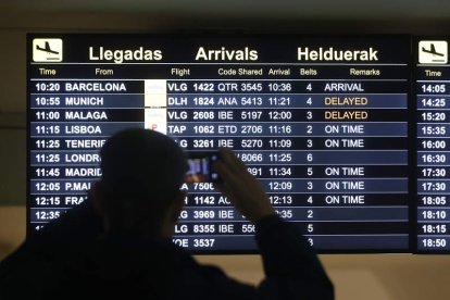 Una persona observa un panel de vuelos este sábado en el aeropuerto de Bilbao. LUIS TEJIDO