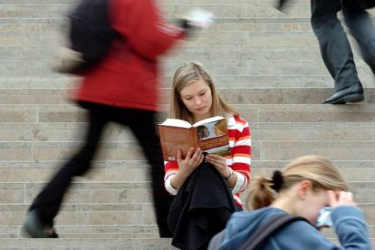 Una mujer lee un libro en plena calle