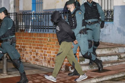 El presunto asesino de tres hermanos en Morata de Tajuña, Dilawar Hussein F.C., sale custodiado por guardias civiles tras el registro de su vivienda en Arganda del Rey.