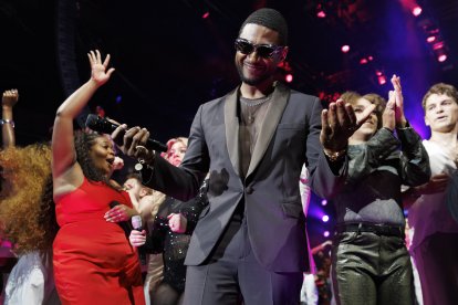 Usher junto a estudiantes de la clase de posgrado en el escenario del Berklee College of Music, después del concierto de graduación en Agganis Arena en Boston,