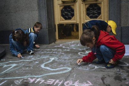 KIS07. KIEV (UCRANIA), 05/06/2014.- Varios niños refugiados de las regiones del este de Ucrania y Crimea dibujan con tiza en el suelo durante una protesta en la entrada del Parlamento ucraniano en Kiev (Ucrania) hoy, jueves 5 de mayo del 2014. Más de 10.000 personas han abandonado sus hogares desde el comienzo de la crisis ucraniana, según la agencia para los refugiados de la ONU. EFE/Roman Pilipey