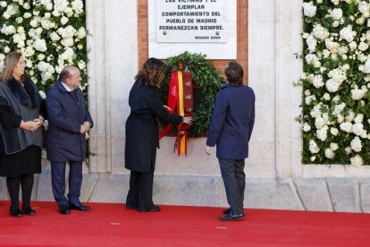 El alcalde de Madrid, José Luis Martínez-Almeida (d), y la presidenta de la Comunidad de Madrid, Isabel Díaz Ayuso, durante una ofrenda floral en el acto en memoria de las víctimas de los atentados ocurridos en Madrid el 11 de marzo de 2004 y en homenaje a los cuerpos de seguridad, servicios de emergencias y ciudadanos que las auxiliaron en la Puerta del Sol en Madrid, este lunes.