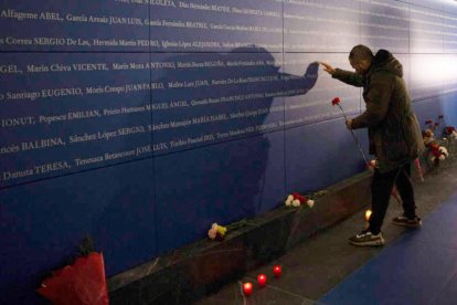 Una persona deposita un clavel en memoria de las víctimas durante el acto celebrado con motivo del aniversario del atentado del 11-M en Madrid.