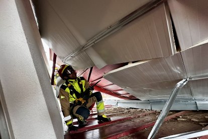 Bomberos de León en la cubierta dañada este miércoles en Pinilla por el viento.