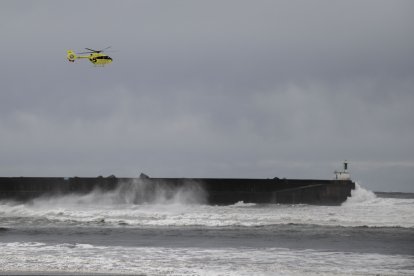 Un helicóptero de rescate trabaja en la localidad asturiana de San Esteban de Pravia este jueves, donde ha fallecido un turista británico que mientras contemplaba el oleaje cayó al agua y fue arrastrado por las olas. Su cuerpo sin vida fue recuperado del mar por un helicóptero de los servicios de emergencias. A menos de siete kilómetros, en el vecino concejo de Cudillero, el fuerte oleaje también dificultó el rescate de una mujer que al parecer fue arrastrada por una ola cuando se encontraba paseando por el puerto pesquero.