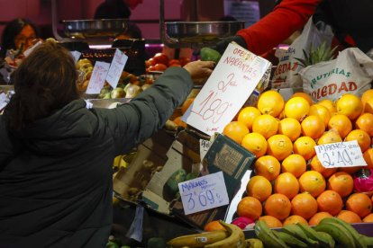 Una consumidora compra en un puesto de frutas y verduras en un mercado de abastos de Madrid, este miércoles.