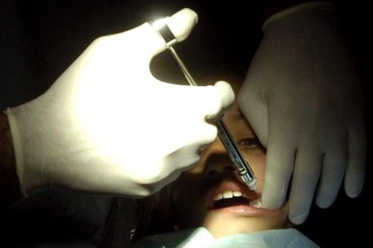 Un dentista atiende a una niña.