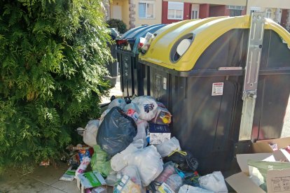 Contenedores a reventar en San Andrés del Rabanedo con los residuos desparramados por el suelo.