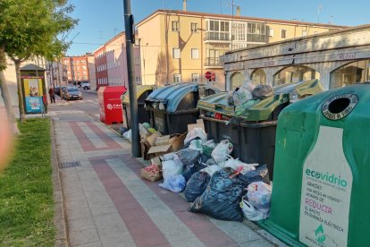 Contenedores a reventar en San Andrés del Rabanedo con los residuos desparramados por el suelo.